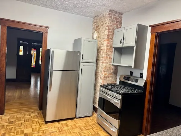 a kitchen with a refrigerator a stove and a cabinets