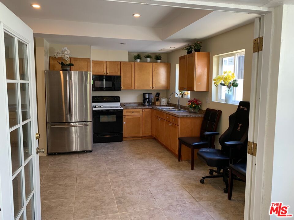 6856 Quinton Lane Tujunga, CA 91042 - Photo 7 of 7 a kitchen with stainless steel appliances kitchen island granite countertop a refrigerator and a stove top oven