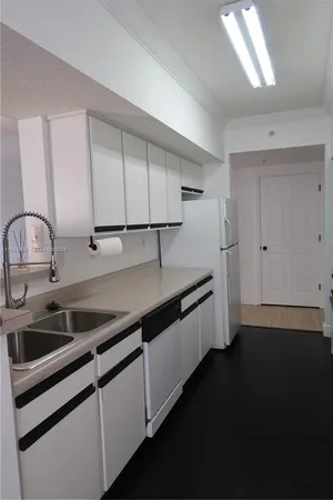 a kitchen with granite countertop a refrigerator stove and sink