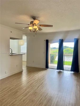 wooden floor in an empty room with a chandelier fan