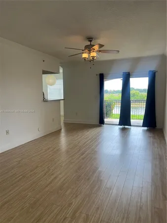 a view of a room with wooden floor and chandelier