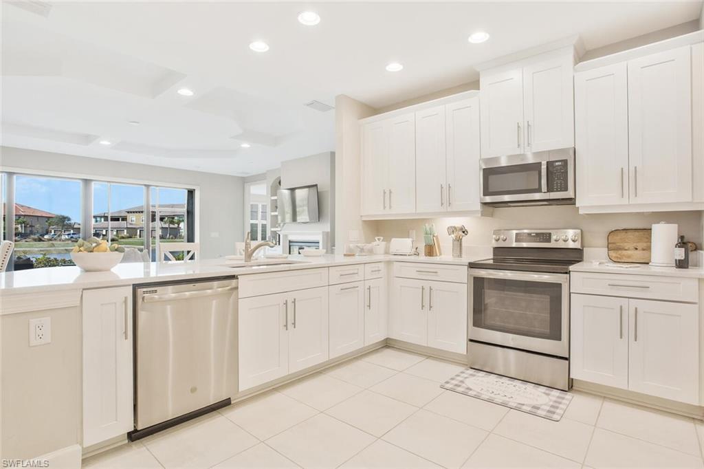 9650 Montelanico Loop, Unit 103 Naples, FL 34119 - Photo 20 of 29 a kitchen with granite countertop white cabinets and white appliances