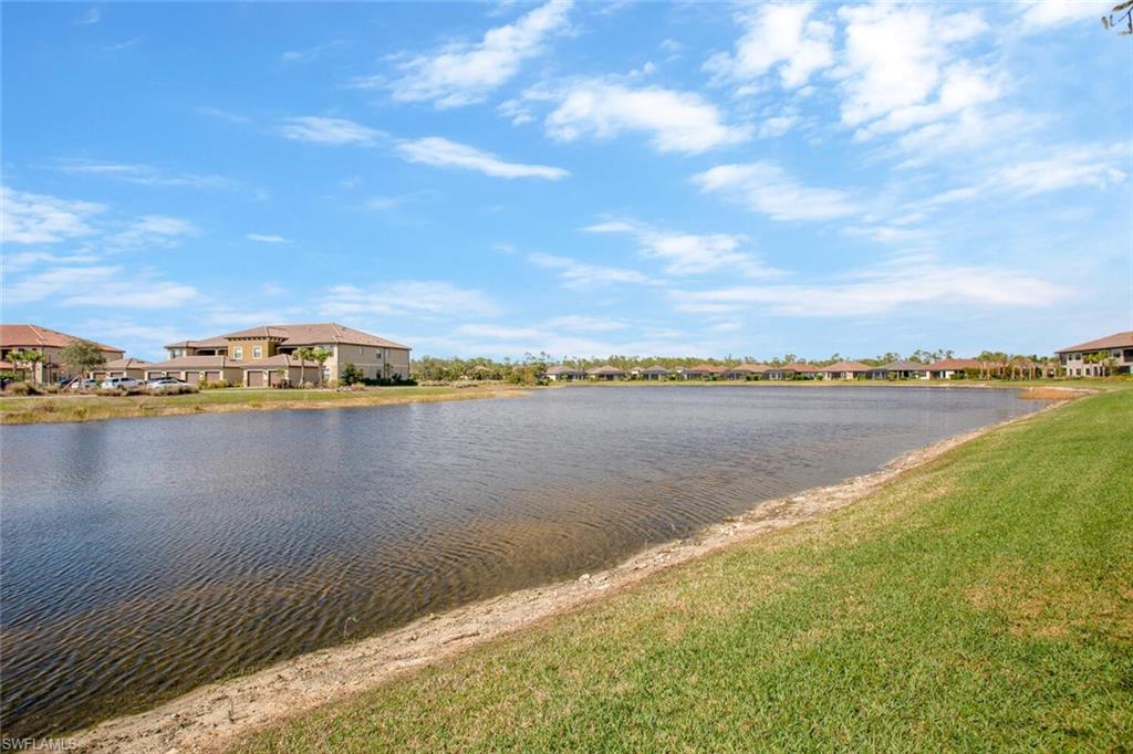 9650 Montelanico Loop, Unit 103 Naples, FL 34119 - Photo 25 of 29 a view of a lake with houses in the back