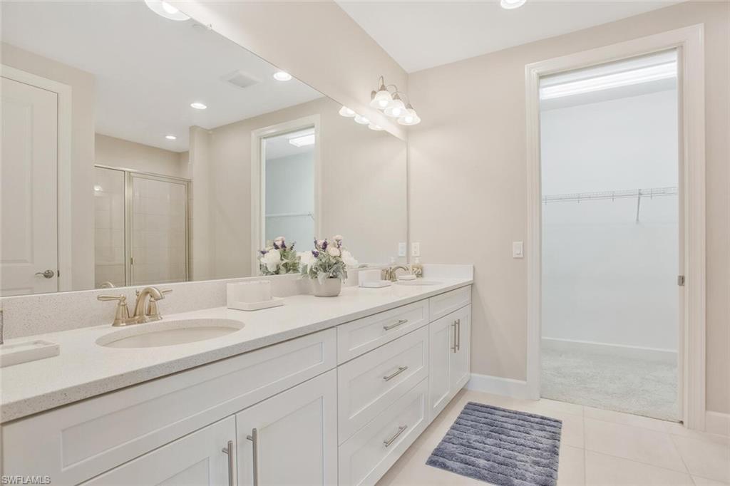 9650 Montelanico Loop, Unit 103 Naples, FL 34119 - Photo 6 of 29 a bathroom with a sink double vanity and a mirror