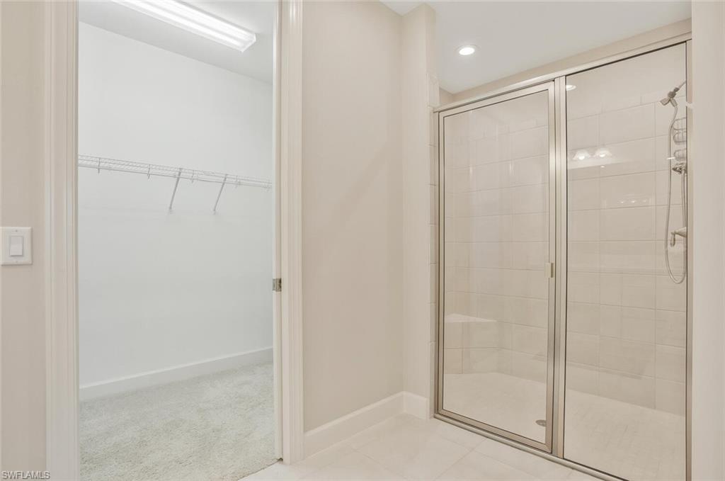 9650 Montelanico Loop, Unit 103 Naples, FL 34119 - Photo 7 of 29 a bathroom with a glass shower door