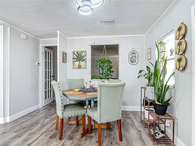 a living room with furniture dining table a fireplace and a dining table with kitchen view