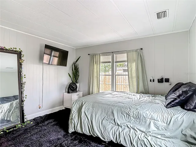 a bedroom with a bed and a large window