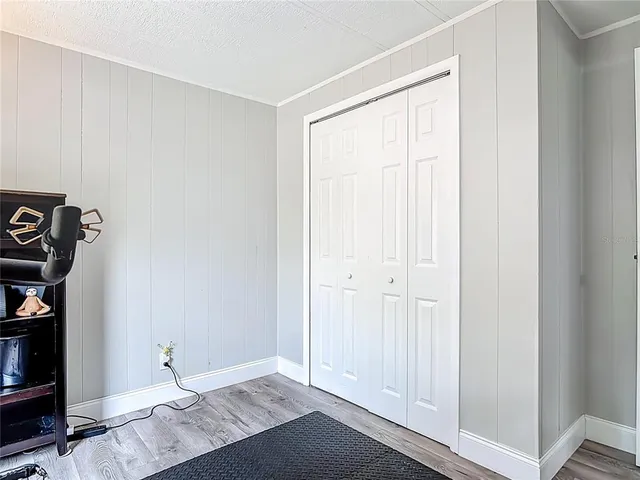 an empty room with wooden floor and closet area