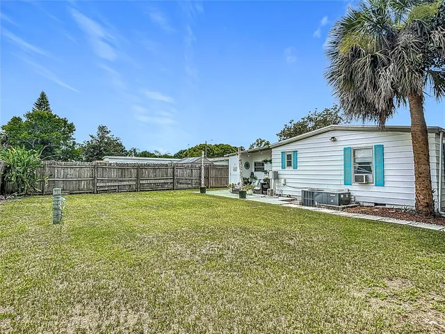 a view of a house with a backyard and a tree