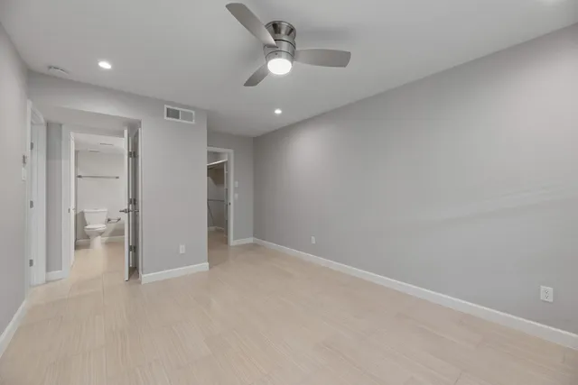 an empty room with fan and entrance