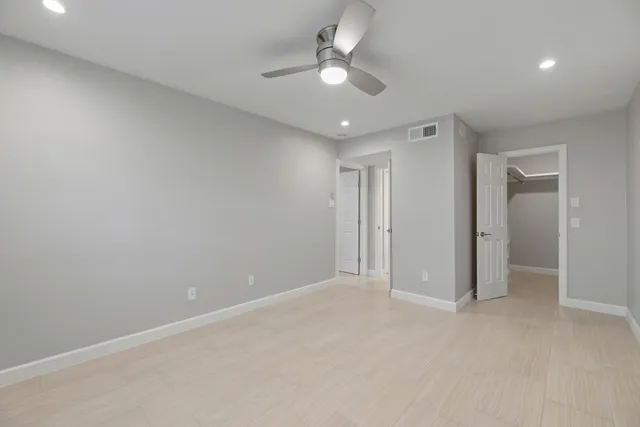 an empty room with a ceiling fan and a window
