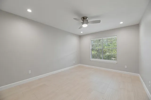 an empty room with a window and a fan