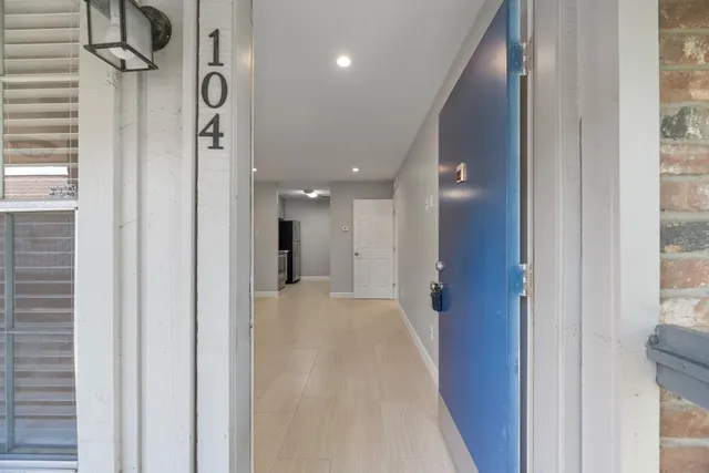 a view of a hallway with a door and stairs