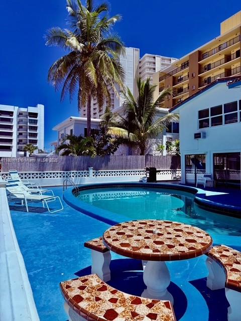 3212 Northeast 8th Court, Unit 12 Pompano Beach, FL 33062 - Photo 13 of 17 a front view of a house with swimming pool having outdoor seating