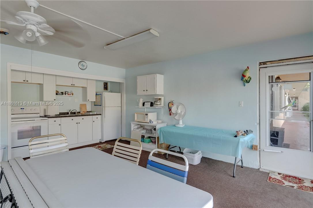 3212 Northeast 8th Court, Unit 12 Pompano Beach, FL 33062 - Photo 15 of 17 a kitchen with white cabinets and window