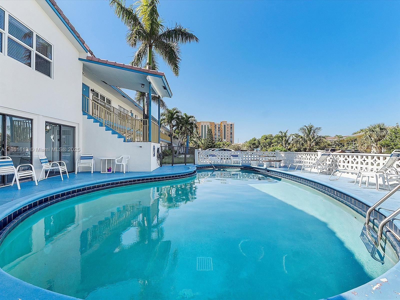 3212 Northeast 8th Court, Unit 12 Pompano Beach, FL 33062 - Photo 16 of 17 a swimming pool with outdoor seating and yard