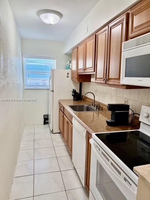3212 Northeast 8th Court, Unit 12 Pompano Beach, FL 33062 - Photo 3 of 17 a kitchen with a sink a stove and cabinets