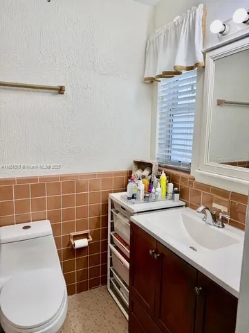 a bathroom with a sink a toilet and mirror
