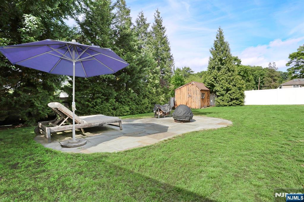 87 Barbara Road Dumont, NJ 07628 - Photo 44 of 48 a view of a backyard with table and chairs under an umbrella