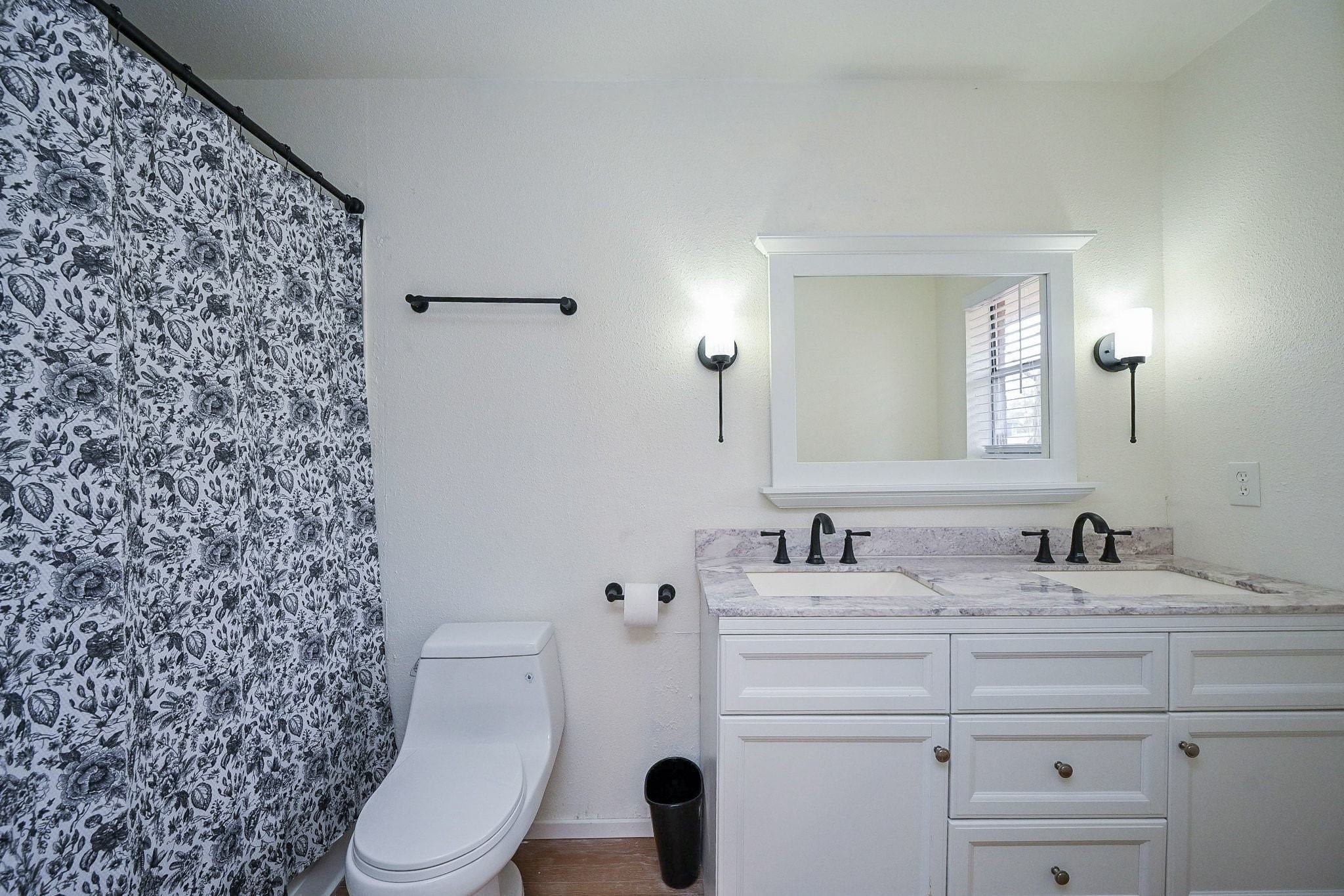 17831 Magnolia Lane New Caney, TX 77357 - Photo 17 of 27 Discover this lovely primary bathroom! The beautiful vanity mirror offers a modern design and the double sinks are perfect for you and your partner! The beautiful countertops complimented by the crisp, white cabinetry give this bathroom the perfect design! Also, notice the light fixtures that are uniquely placed!