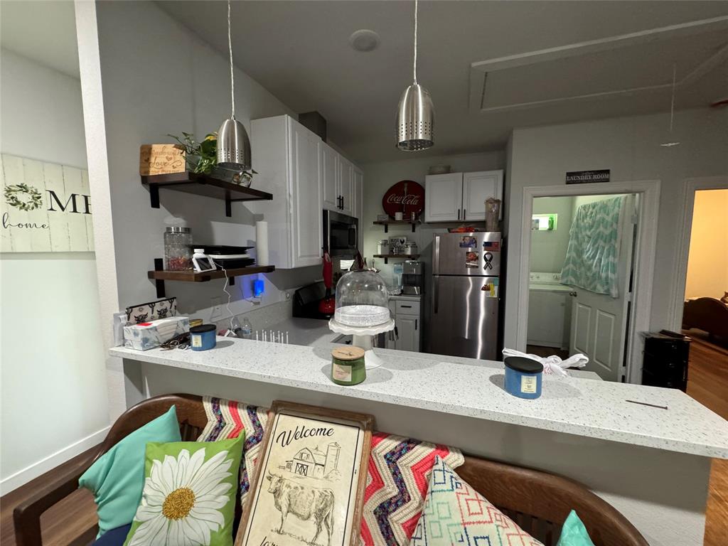 1307 West 33rd Street Tyler, TX 75702 - Photo 3 of 5 a kitchen with a sink a stove and chairs