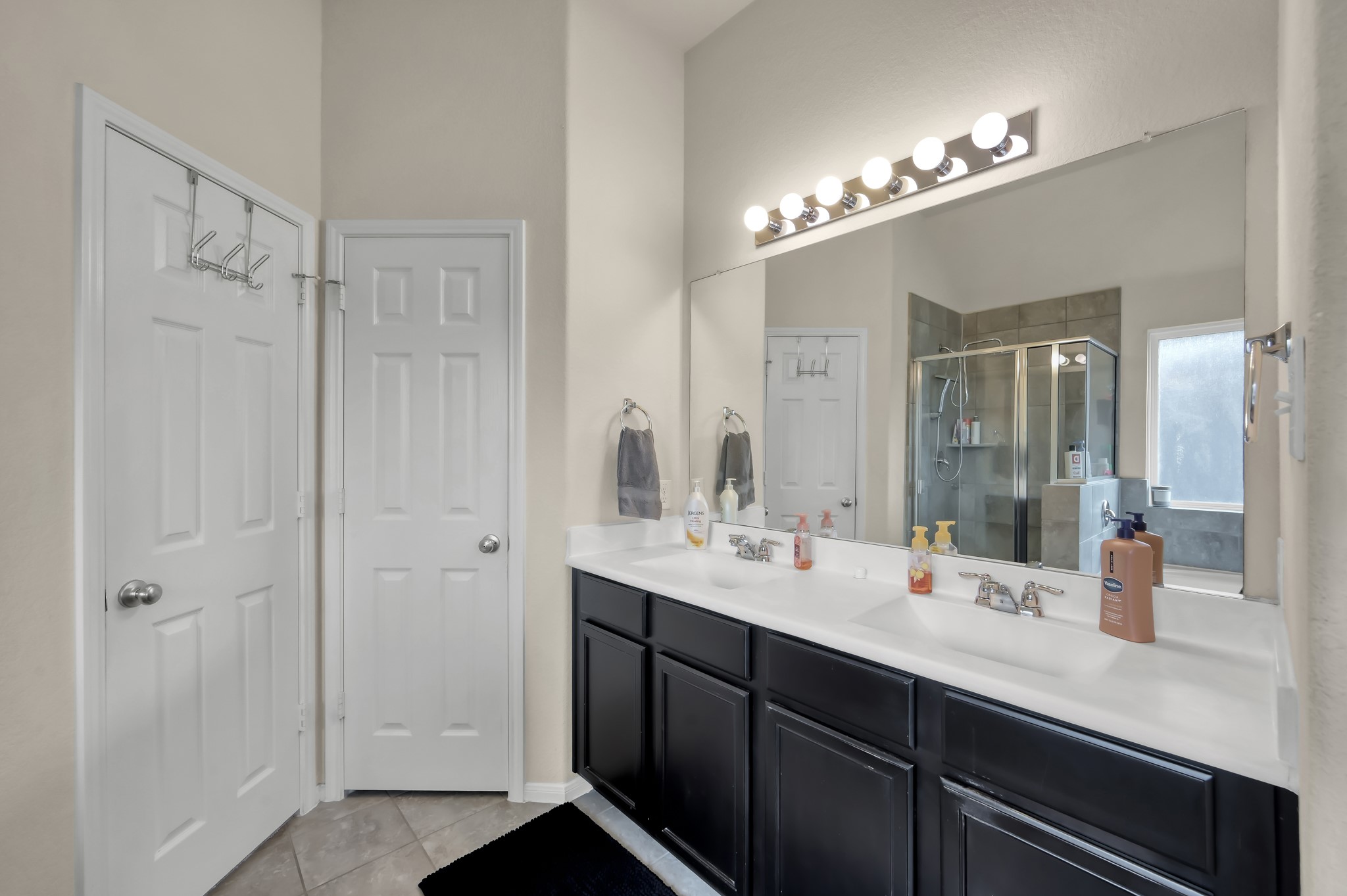 21550 Rainfall Park Drive Spring, TX 77388 - Photo 17 of 38 a bathroom with double vanity sinks a vanity a lamp and a mirror