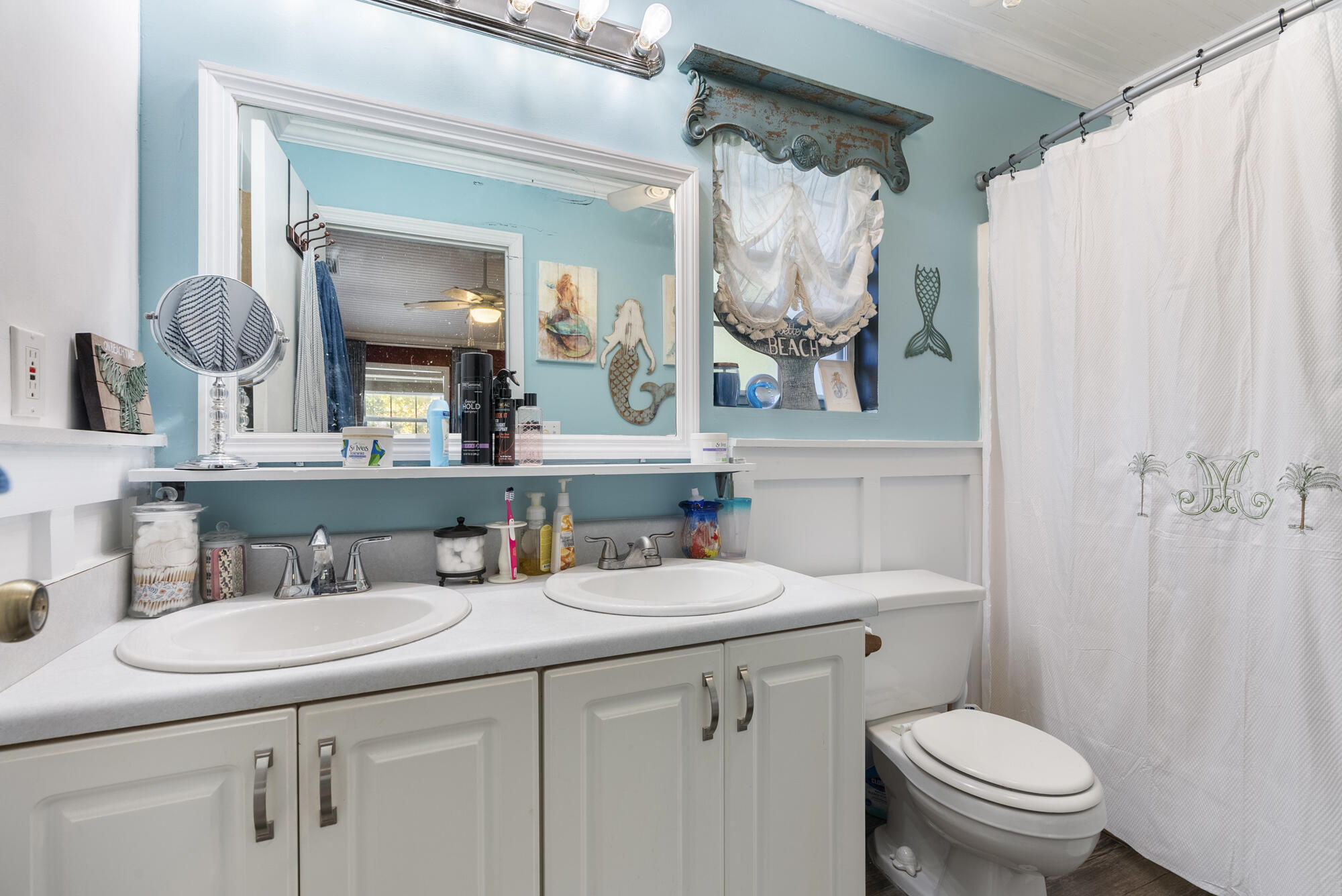 902 Northwest Ave D Carrabelle, FL 32322 - Photo 17 of 32 a bathroom with a sink a toilet and a mirror