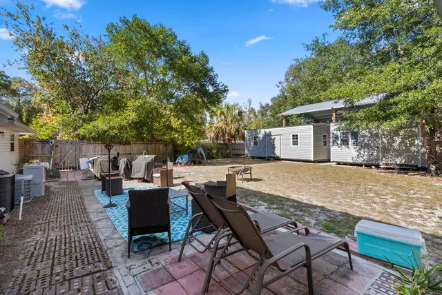 a backyard of a house with barbeque oven table and chairs