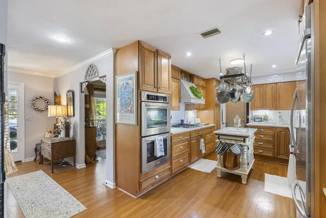 a kitchen with stainless steel appliances granite countertop a refrigerator a stove top oven and a sink