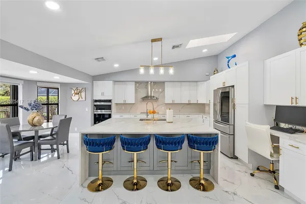 a kitchen with a dining table chairs refrigerator and cabinets