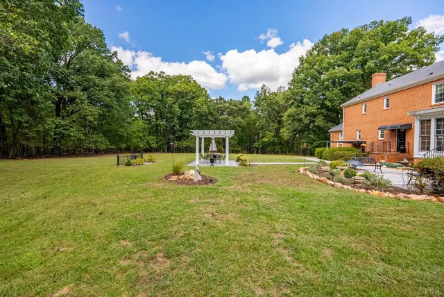 a front view of a house with garden and trees