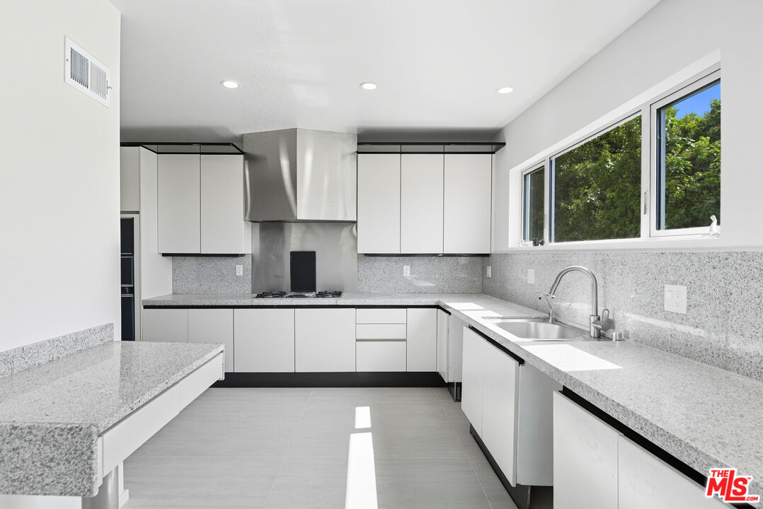 1591 Lindacrest Drive Beverly Hills, CA 90210 - Photo 6 of 17 a kitchen with a sink window and cabinets