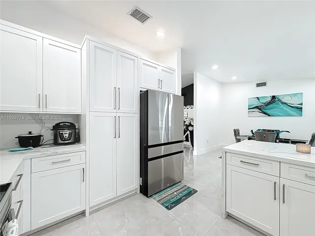 a kitchen with white cabinets and white appliances