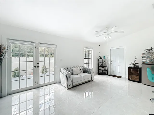 a living room with furniture and large windows