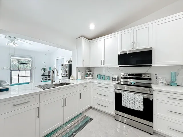 a kitchen with appliances a sink and cabinets