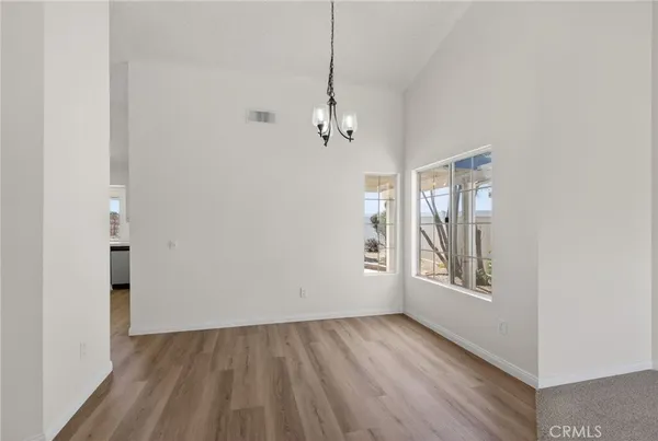 a large kitchen with a wooden floor and a refrigerator