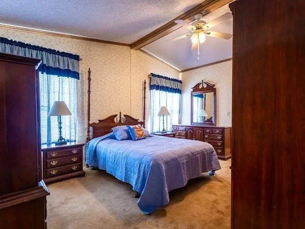 a bed sitting in a bedroom next to a window and a chandelier