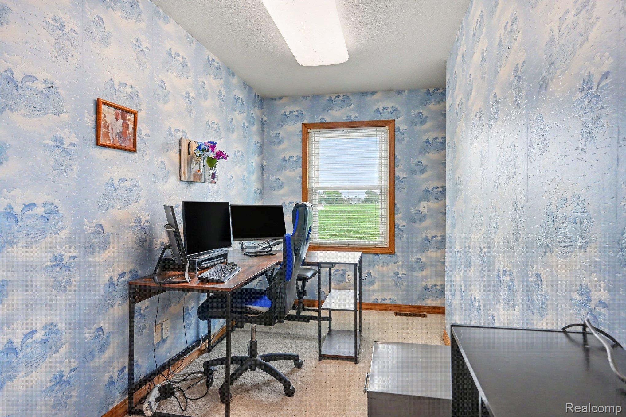 996 Arbogast Road Union City, MI 49094 - Photo 16 of 34 Room featuring light blue patterned wallpaper, a single casement window with wood trim, and a drop ceiling