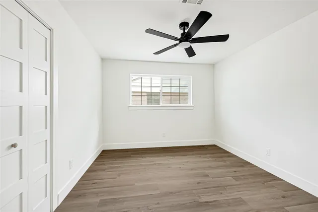 a view of a big room with wooden floor and windows