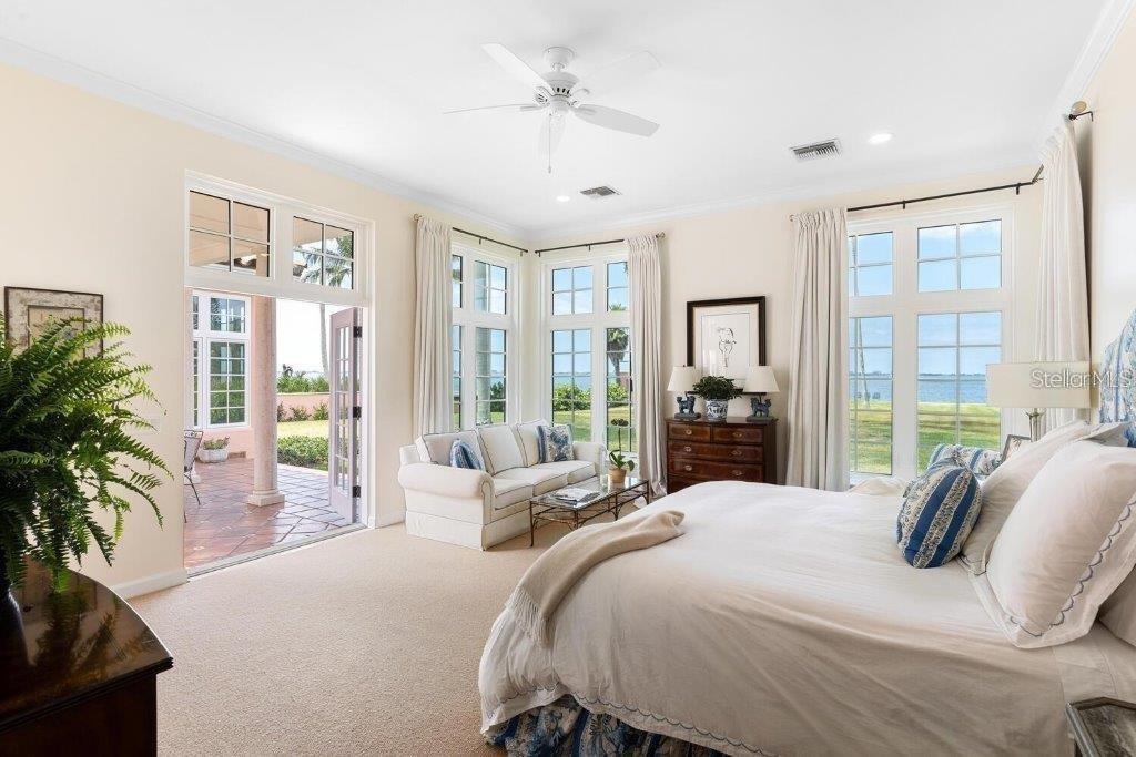 4511 Bay Shore Road Sarasota, FL 34234 - Photo 26 of 69 a bedroom with a balcony a large bed and a chandelier