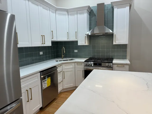 a kitchen with stainless steel appliances a sink a stove and a refrigerator