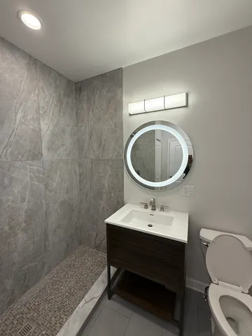 a bathroom with a sink toilet and a mirror