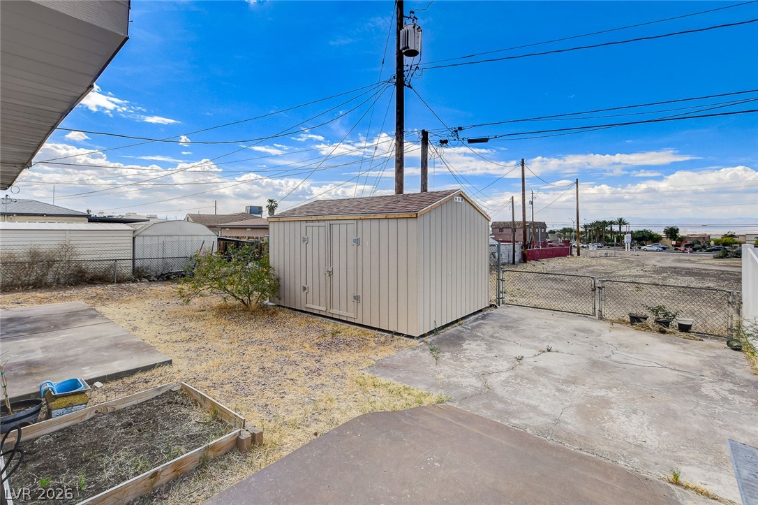 214 West Victory Road Henderson, NV 89015 - Photo 31 of 33 A detached storage shed and a paved driveway anchor this functional backyard space.
