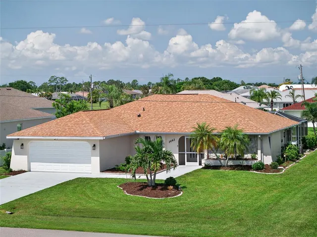 a front view of a house with a garden and trees