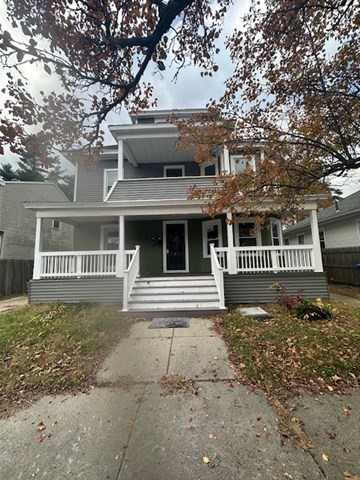 a view of a house with a tree in front of it