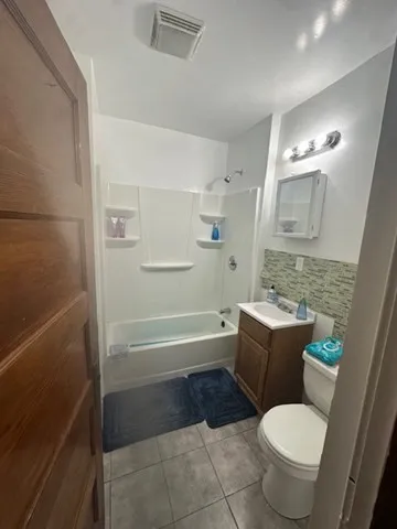 a bathroom with a granite countertop toilet a sink and bathtub