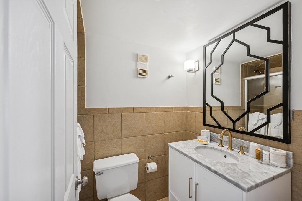 236 Edgemere Street, Unit 427 Montauk, NY 11954 - Photo 11 of 42 Bathroom with tile walls, vanity, and a shower stall