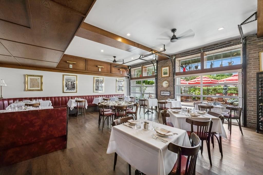 236 Edgemere Street, Unit 427 Montauk, NY 11954 - Photo 16 of 42 Dining area with a ceiling fan, healthy amount of natural light, wood finished floors, and brick wall