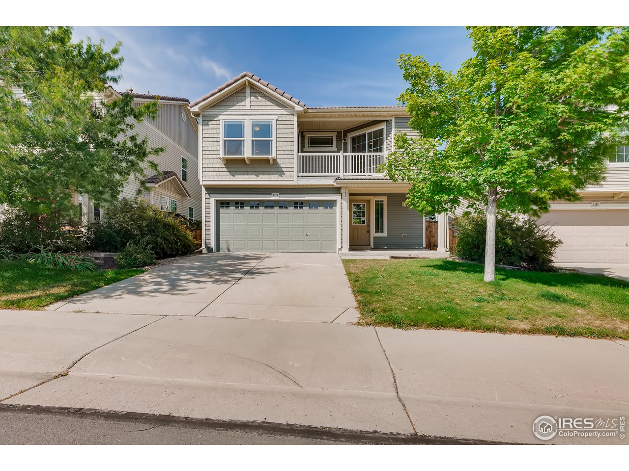 a front view of a house with a yard and trees