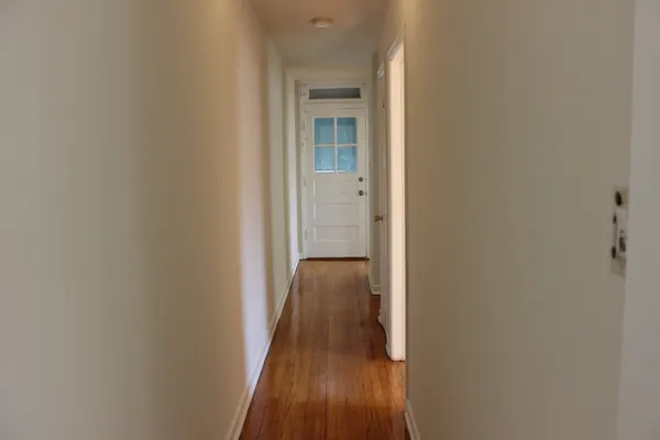 a view of a hallway with wooden floor